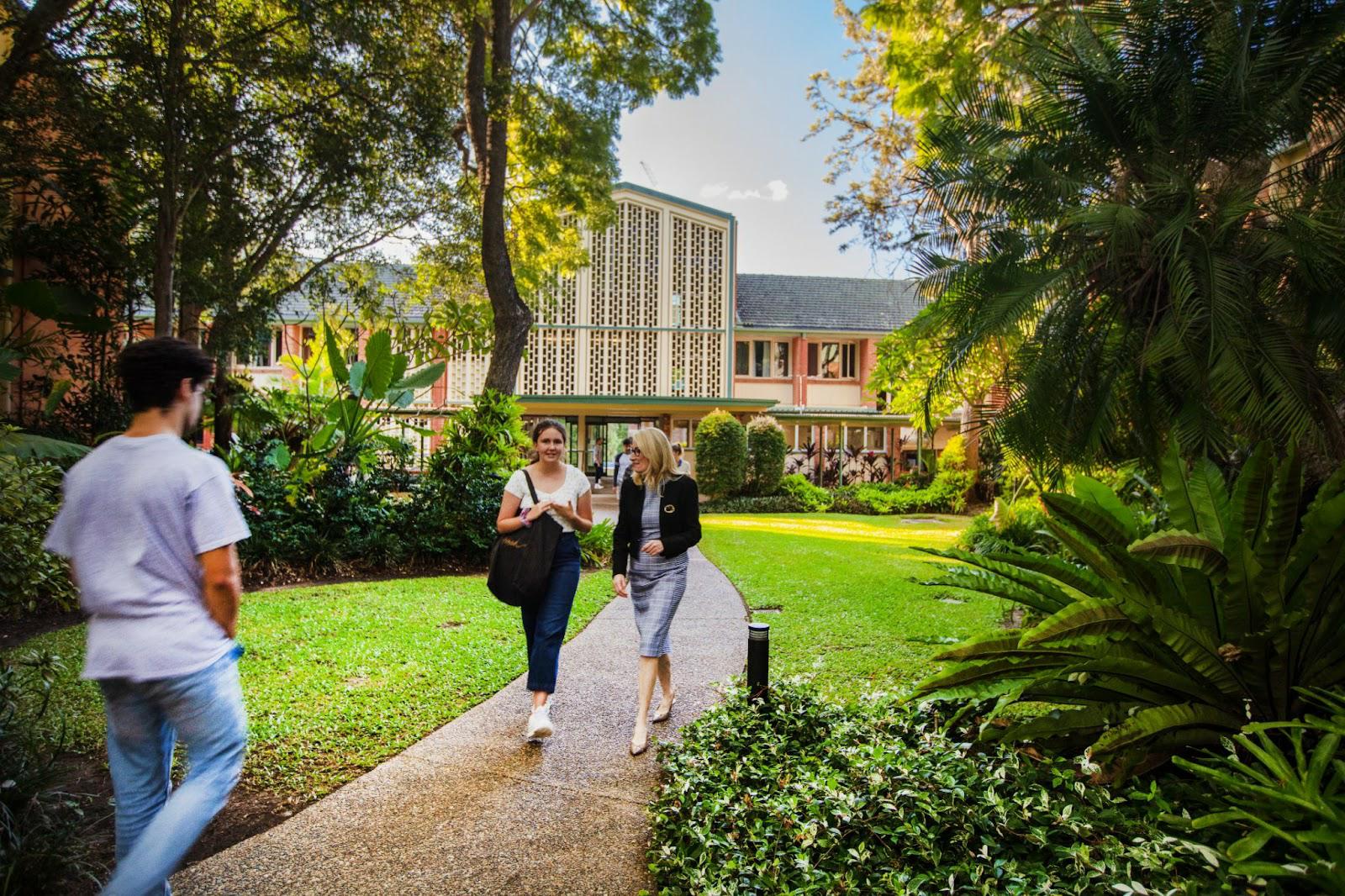 St John's student walking with St John's Warden, Rose Alwyn, through the college grounds