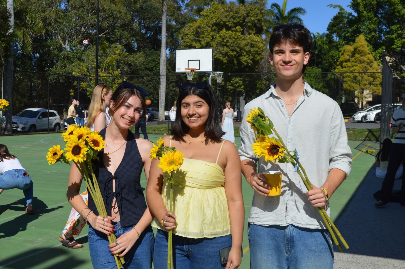 Students with sunflowers in the sunshine